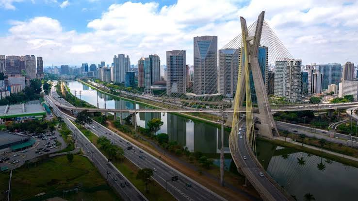 Vista aérea de São Paulo com prédios, avenidas movimentadas e a ponte estaiada