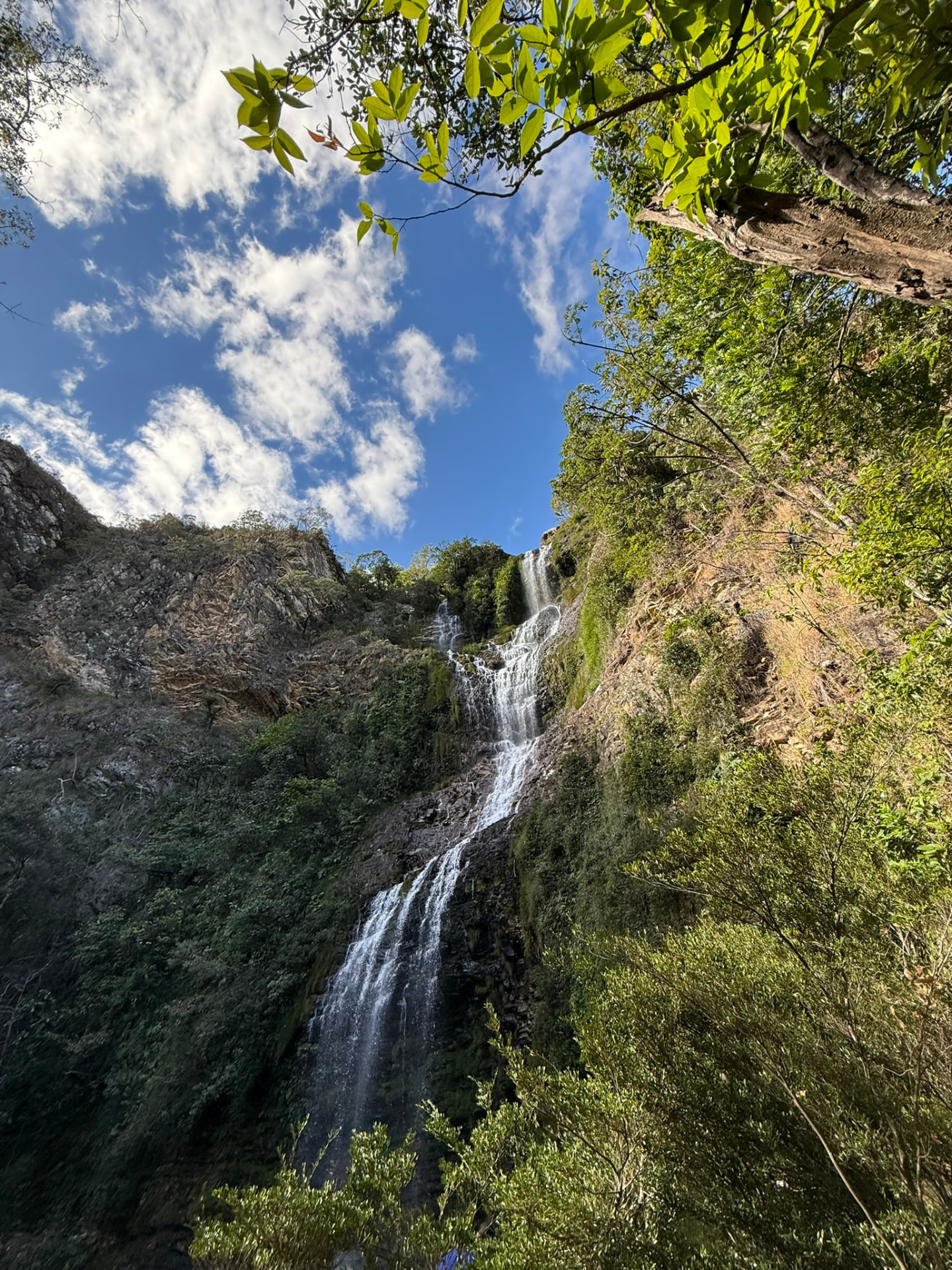 Cachoeira alta cercada de mata na Serra do Cipó
